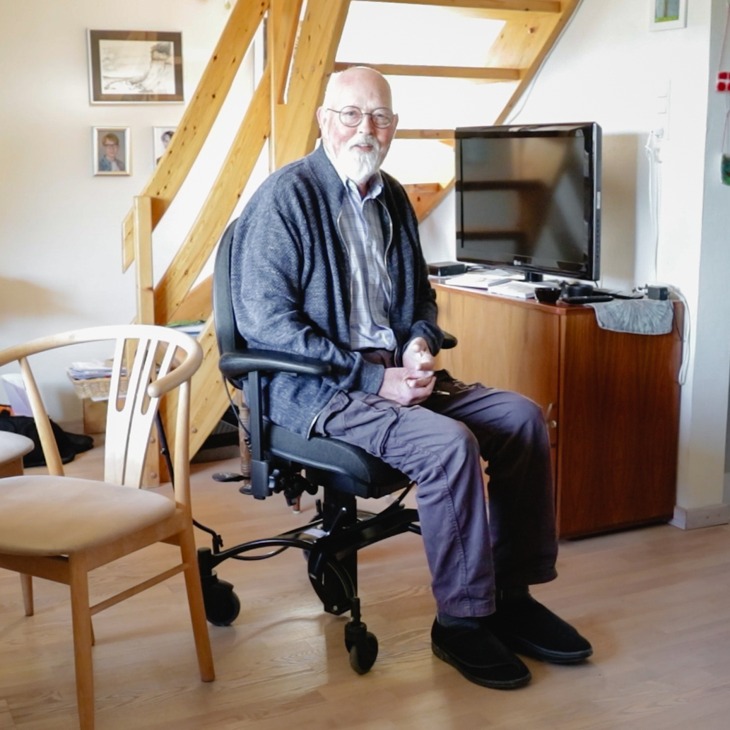 zufrieden mit seinem VELA-Stuhl als Hilfsmittel zur Sturzprophylaxe